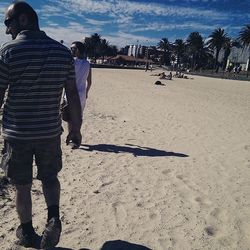 Rear view of people walking on beach