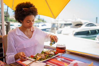 Portrait of young woman having food at restaurant