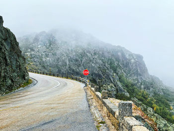 Road by mountains against sky