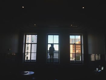 Silhouette people walking in corridor of building