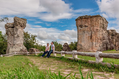 People on stone structure against sky