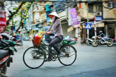 Woman riding bicycle on city street