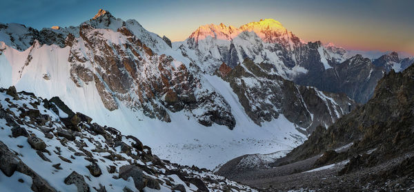 Scenic view of snowcapped mountains against sky during sunset