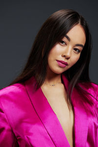 Portrait of young woman against black background