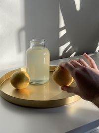 Midsection of person with ice cream in glass jar on table