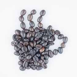 High angle view of coffee beans against white background