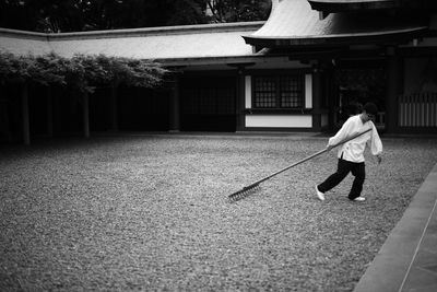 Rear view of woman walking by building