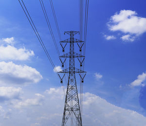 Low angle view of electricity pylon against blue sky