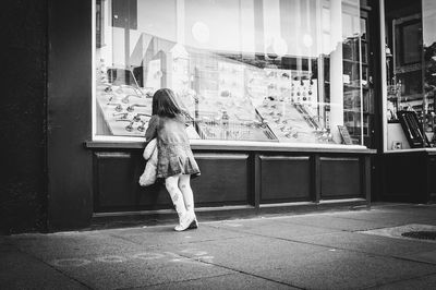 Rear view of woman standing against building