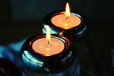 Close-up of illuminated tea light candles on table