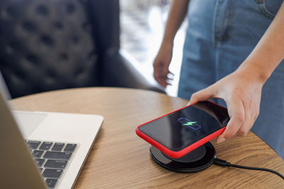 Midsection of man using mobile phone on table