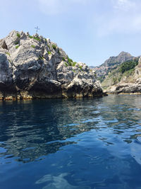 Rock formation in sea against sky