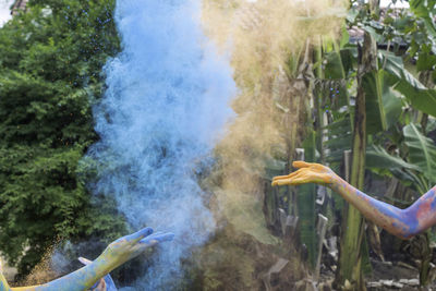 Cropped image of hands throwing powder color during festival