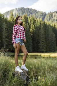 Full length of fashionable young woman standing on field