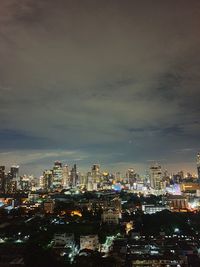 Illuminated buildings in city against sky at night