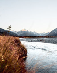 Scenic view of lake against snowcapped mountains and sky