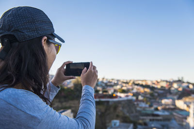 Portrait of man photographing against sky