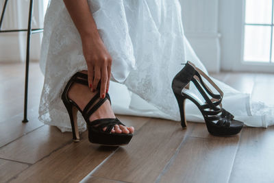 Low section of woman standing on hardwood floor