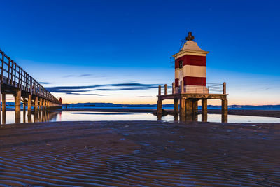 Sunrise over the sea. the lighthouse of lignano sabbiadoro and the games of sand and colors. italy