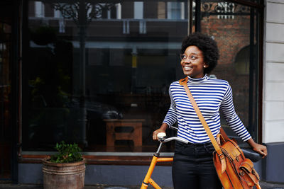 Smiling woman standing against wall