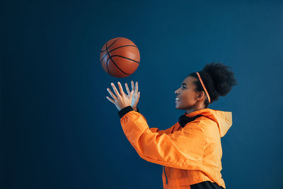 Low angle view of man holding basketball hoop against sky