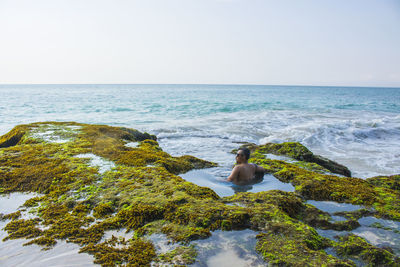 Man looking at sea against clear sky