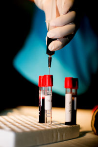 Midsection of doctor examining blood sample in test tube