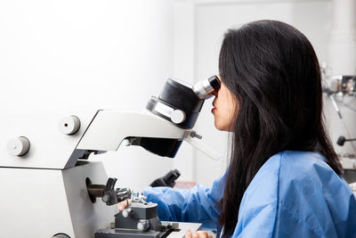 Young female scientist using an ultramicrotome to make sections for the electron microscope.