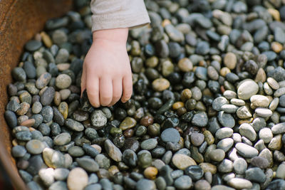 Toddler hand picking up small stones