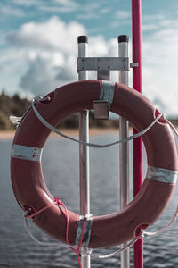 Close-up of metallic structure in sea against sky