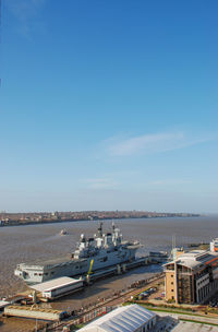 High angle view of city by sea against blue sky