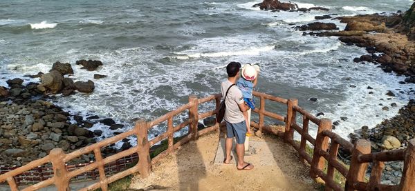 Rear view of men standing on beach