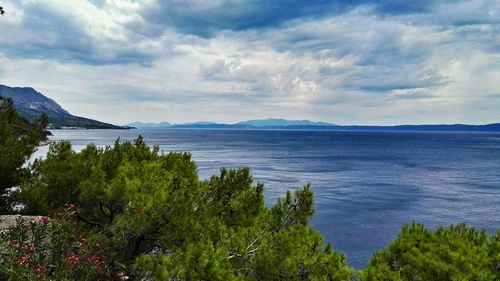 Scenic view of calm sea against cloudy sky