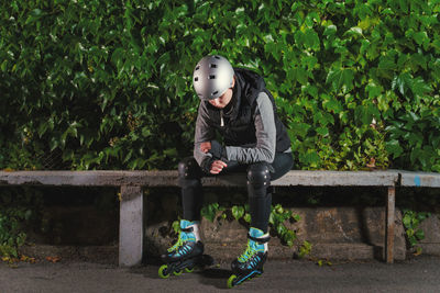 Man sitting on bench against plants