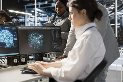 Midsection of woman using laptop at office