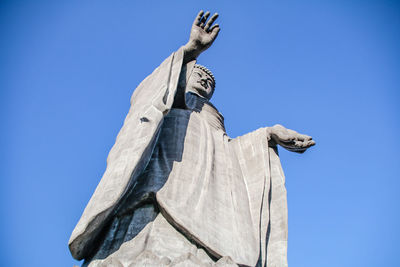 Low angle view of statue against clear blue sky