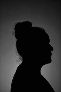 Portrait of silhouette woman against gray background