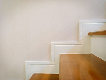 Empty chair against white wall at home