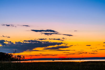 Scenic view of silhouette field against romantic sky at sunset