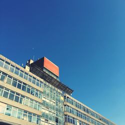 Low angle view of modern building against clear blue sky