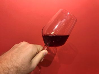Close-up of hand holding glass of red wine