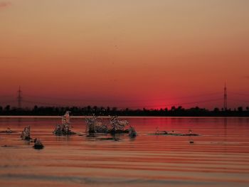 Scenic view of lake against clear sky during sunset