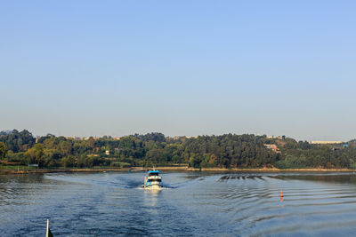 People swimming in sea against clear sky