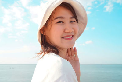 Portrait of smiling woman on beach against sky