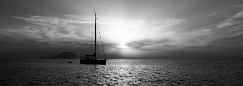 Sailboat in sea at sunset