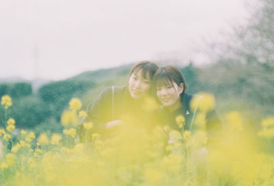 Portrait of woman on yellow flower in field