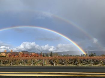 Scenic view of rainbow over landscape against sky