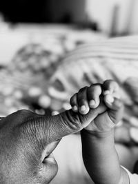 Cropped hand of baby holding father finger