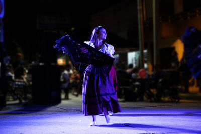 Beautiful young woman dancing italian festival in the street