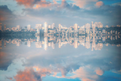 Reflection of illuminated buildings against sky at night